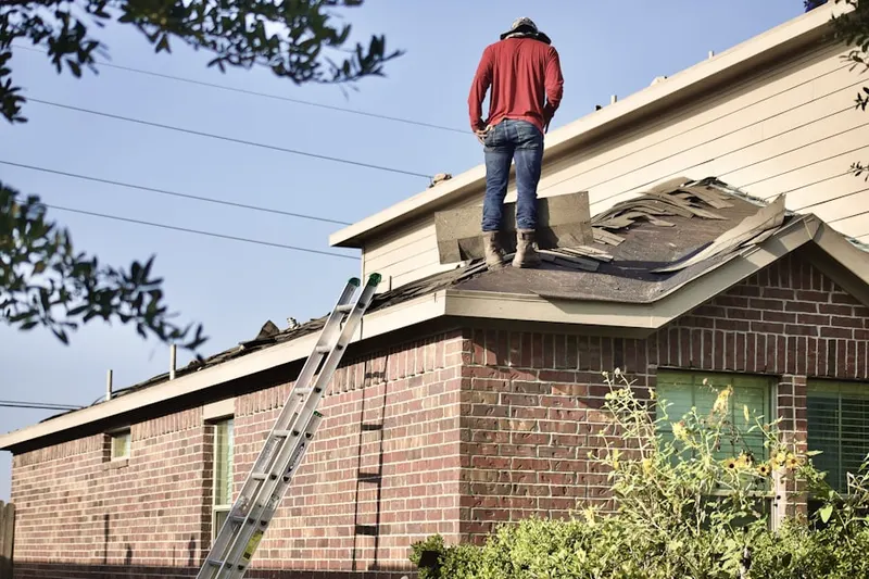 Professional roofer working on a residential roof in Fall River